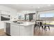Modern kitchen showcasing an island with a stainless steel dishwasher, flowing into an open dining and living space at 18353 W Gray Fox Trl, Wittmann, AZ 85361