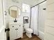 Cozy bathroom featuring a modern vanity, round mirror, and tub with stylish black hardware at 1892 S Arroyo Ln, Gilbert, AZ 85295