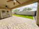 Covered patio with brick pavers and access to a well-maintained backyard with artificial grass and privacy wall at 1892 S Arroyo Ln, Gilbert, AZ 85295