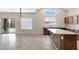 Bright eat-in kitchen with large window, tile floors, and island with a sink at 19616 N Toya St, Maricopa, AZ 85138