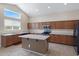 Well-lit kitchen features stainless steel appliances, center island with granite countertops, and ample wood cabinets at 19616 N Toya St, Maricopa, AZ 85138