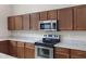Close-up of kitchen with stainless steel appliances, granite countertops, and ample wood cabinets at 19616 N Toya St, Maricopa, AZ 85138