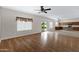 Open floor plan with living room, kitchen, hardwood floors, neutral walls, and sliding glass door to the backyard at 19616 N Toya St, Maricopa, AZ 85138