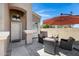Relaxing outdoor patio area features a table with four chairs, a fire pit and a large parasol umbrella at 19616 N Toya St, Maricopa, AZ 85138