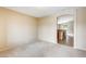 Bright, carpeted living room with neutral walls, an arched doorway, and views to the kitchen at 1979 N Vista Ln, Casa Grande, AZ 85122