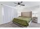 This bedroom features neutral walls, carpet, a ceiling fan, and a tufted headboard at 2425 W Shady Glen Ave, Phoenix, AZ 85023