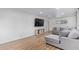 Bright living room with modern flooring, large TV, and comfortable gray sectional at 2425 W Shady Glen Ave, Phoenix, AZ 85023