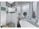 Bright bathroom featuring a soaking tub, glass block window, and a separate shower with stone floor at 2452 W Enfield Way, Chandler, AZ 85286