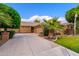 Spacious driveway leading to a three-car garage of a tan colored home with well-maintained landscaping at 2452 W Enfield Way, Chandler, AZ 85286