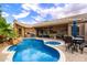 Backyard oasis with a large pool, spa, rock waterfall feature, and outdoor seating, perfect for entertaining at 2452 W Enfield Way, Chandler, AZ 85286