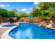 Serene backyard showcasing a pool, spa, rock waterfall, and lush landscaping at 2452 W Enfield Way, Chandler, AZ 85286