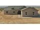 A front view of a newly constructed home featuring neutral tones and a desert landscape at 25721 W Running Deer Trl, Wittmann, AZ 85361