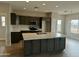 Open kitchen with stainless steel appliances, large island, and gray cabinetry at 25875 W Running Deer Trl, Wittmann, AZ 85361