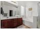 A bright bathroom offering a double sink vanity, bathtub and shower at 2612 W Summerside Rd, Phoenix, AZ 85041