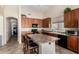 An open kitchen offers an island with bar stool seating, cabinetry, and modern appliances at 2612 W Summerside Rd, Phoenix, AZ 85041