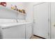 Practical laundry room with washer, dryer, and shelving for storage at 2612 W Summerside Rd, Phoenix, AZ 85041