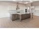 Bright kitchen features a large central island with a stone countertop, white cabinets, and modern appliances at 26696 W Siesta Ln, Buckeye, AZ 85396