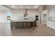 Bright kitchen features a large central island with a stone countertop, white cabinets, and modern appliances at 26696 W Siesta Ln, Buckeye, AZ 85396
