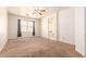 Expansive bedroom with carpet flooring, a ceiling fan, and bright natural light from the window at 3107 S 74Th Ln, Phoenix, AZ 85043