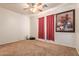 Bedroom featuring carpet floors, a ceiling fan, red curtains, and floral painting at 3107 S 74Th Ln, Phoenix, AZ 85043