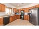 Functional kitchen with stainless steel appliances, wooden cabinets, and tiled floors at 3107 S 74Th Ln, Phoenix, AZ 85043