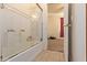 Bathroom shower with white tile surround and glass doors, leading to bedroom at 3107 S 74Th Ln, Phoenix, AZ 85043
