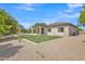 Expansive backyard featuring a covered patio, lush lawn area, and a sparkling swimming pool with mature trees at 3461 E Indigo Cir, Mesa, AZ 85213