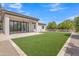 Inviting backyard features a covered patio, ample grass, and attractive desert landscaping for outdoor enjoyment at 3461 E Indigo Cir, Mesa, AZ 85213