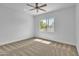 Bright bedroom featuring a ceiling fan, neutral carpet, and a large window offering natural light at 3461 E Indigo Cir, Mesa, AZ 85213