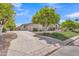 Expansive driveway leading to a well-maintained home with lush landscaping and mature citrus trees at 3461 E Indigo Cir, Mesa, AZ 85213