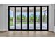 Folding glass doors lead to a covered patio and landscaped backyard with artificial grass at 3461 E Indigo Cir, Mesa, AZ 85213