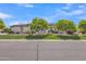 Charming single-story home with a well-manicured lawn and mature trees providing shade and curb appeal at 3461 E Indigo Cir, Mesa, AZ 85213