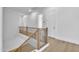 Hallway with wooden floors, iron railing, and white molding showcases modern design and craftsmanship at 3461 E Indigo Cir, Mesa, AZ 85213