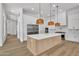 Bright, spacious kitchen with an island, stainless steel appliances, wooden floors, and modern lighting fixtures at 3461 E Indigo Cir, Mesa, AZ 85213