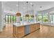 A sun-lit kitchen with a large center island and stainless steel appliances provides open backyard views at 3461 E Indigo Cir, Mesa, AZ 85213