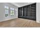 Spacious living room with custom built-in shelving and light wood flooring at 3461 E Indigo Cir, Mesa, AZ 85213