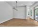 Minimalist living room with wood flooring, a modern chandelier, and bright lighting at 3461 E Indigo Cir, Mesa, AZ 85213