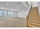 Expansive living room featuring new wood flooring, staircase to the upper level, and natural light at 3461 E Indigo Cir, Mesa, AZ 85213