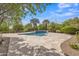Inviting backyard pool with travertine tile surround and lush tropical landscaping creates a private oasis at 3461 E Indigo Cir, Mesa, AZ 85213