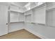 Bright walk-in closet offering generous storage space with adjustable shelves and durable wood flooring at 3461 E Indigo Cir, Mesa, AZ 85213