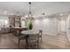 Open dining area features modern chandelier, wood floors, easy access to the kitchen, and neutral tones at 3632 E Poinsettia Dr, Phoenix, AZ 85028