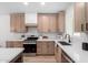 Contemporary kitchen features bright countertops, a stainless steel dishwasher, modern fixtures, and light wood cabinets at 3632 E Poinsettia Dr, Phoenix, AZ 85028