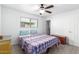 Comfortable bedroom featuring a window, ceiling fan, and an inviting patterned duvet cover on the bed at 3736 W Hazelwood St, Phoenix, AZ 85019