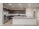 New kitchen with granite countertops, stainless refrigerator, and modern microwave at 4107 S 176Th Dr, Goodyear, AZ 85338