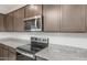 Close-up of kitchen's stainless steel microwave, electric range, and granite counters at 4107 S 176Th Dr, Goodyear, AZ 85338