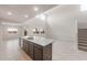 Bright, open-concept living area with kitchen bar, light tile floors, and stairs at 4107 S 176Th Dr, Goodyear, AZ 85338