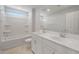 Modern bathroom with double sinks, sleek white cabinets, and a bright shower-tub combo at 4113 S 176Th Dr, Goodyear, AZ 85338