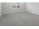 Neutral bedroom with plush gray carpeting, a large window, and a peaceful atmosphere at 4113 S 176Th Dr, Goodyear, AZ 85338