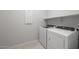 Bright laundry room with new white washer and dryer, complemented by built-in shelving at 4113 S 176Th Dr, Goodyear, AZ 85338