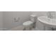 Powder room featuring classic pedestal sink and toilet against neutral walls at 4113 S 176Th Dr, Goodyear, AZ 85338